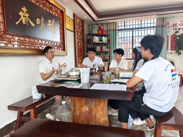 圖為團隊成員與鵲鳴春茶葉有限公司總經理羅述長進行交流